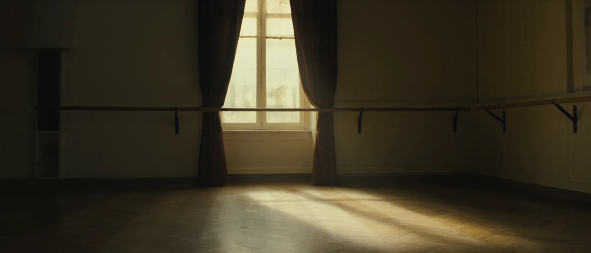 The empty Velour studio: herringbone parquet, drawn velvet drapes and one tall window casting late light across the floor